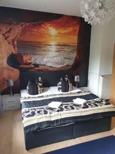 a bedroom with a painting of the ocean at Pension Parkblick in Braunlage +37 photos