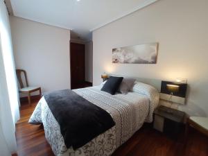 a bedroom with a bed and a table and a chair at Pedroenea Apartamento Elizondo in Elizondo