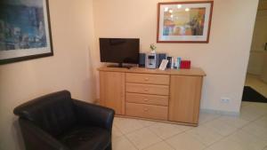 a living room with a chair and a television on a dresser at Atlantik 3.07-3Zi.-Meerblickwohnung in Kühlungsborn