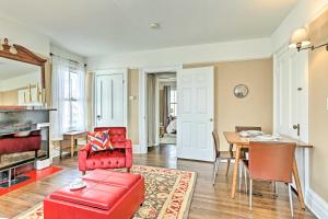 Historic Poughkeepsie Apt - Walkable Location في باوكيبسي: غرفة معيشة بأثاث احمر وطاولة