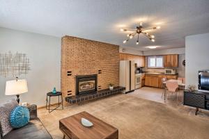 a living room with a fireplace and a kitchen at Deadwood Apartment - Walk to Historic Downtown! in Deadwood
