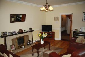 sala de estar con chimenea y TV en Palmgrove Bed & Breakfast, en Listowel