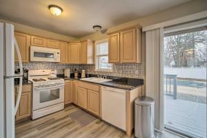 a kitchen with wooden cabinets and white appliances at Charming Somers Point House with Private Pool! in Somers Point