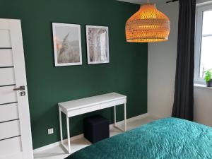 シフィエラドゥフ・ズドルイにあるPrzy Zajęcznikuの緑のベッドルーム(ベッド1台、テーブル付)