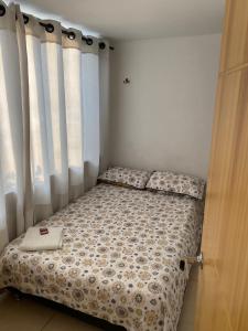 a small bed in a room with a window at Luxury Hostal in Manizales