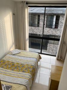 a bedroom with a bed and a large window at Luxury Hostal in Manizales