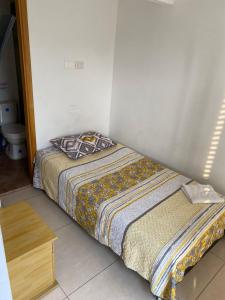 マニサレスにあるLuxury Hostalの木製テーブル付きの客室の小さなベッド1台分です。