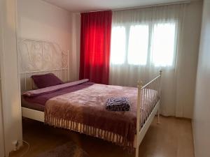 sypialnia z łóżkiem i oknem z czerwonymi zasłonami w obiekcie Villa Talmo w mieście Kemionsaari