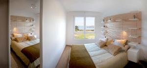 a bedroom with two beds and a window at Apartamento Paseo Marítimo Laxe in Laxe