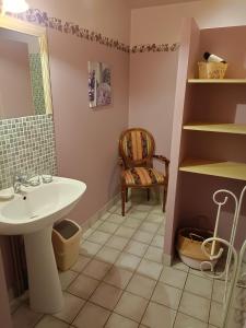 La salle de bains est pourvue d'un lavabo et d'une chaise. dans l'établissement Gîte Le Pré du Roc, à Bromont-Lamothe