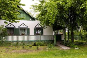 a white house with a green and white fence at Kisparaszt Vendégház in Zákányszék