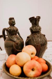 a plate of apples on a table next to a vase at Kisparaszt Vendégház in Zákányszék