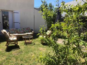 a living room with a couch and a table in a yard at Maison les figuiers Roch Priol in Quiberon +7 photos