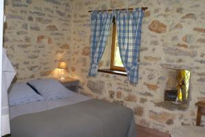 sypialnia z łóżkiem i oknem w obiekcie Chambres d'hôtes La Combe de Redoles w mieście Tour-de-Faure