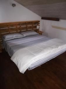 uma cama grande num quarto com lençóis brancos em Belvedere Bronte 01 e Belvedere Bronte 02 em Bronte