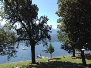 - une vue sur un lac avec des personnes assises sur l'herbe dans l'établissement Osteria La Riva, à Locarno
