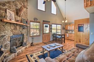sala de estar con chimenea de piedra y mesa en Andrews Cabin with Fireplace, Deck and Mountain Views! en Andrews
