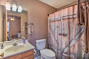 baño con aseo y ducha con puerta de madera en Andrews Cabin with Fireplace, Deck and Mountain Views! en Andrews