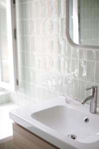 a white bathroom with a sink and a mirror at Villa Jeanne - Confort et plage in Le Tréport