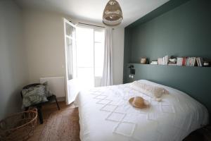 a bedroom with a bed with a hat on it at Villa Jeanne - Confort et plage in Le Tréport