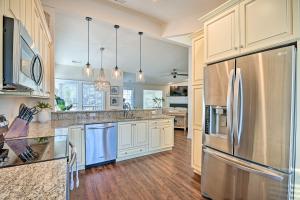 a kitchen with white cabinets and a stainless steel refrigerator at Resort Villa on Golf Course with Beach Access! in Pawleys Island