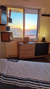 una camera da letto con un letto e una grande finestra di Résidence Château Leenhardt - Appartement T2 Face à la Mer a Le Grau-du-Roi