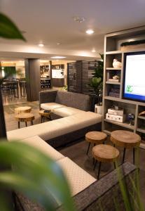 a living room with a couch and tables and a tv at Oxford Suites Portland - Jantzen Beach in Portland