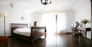 a bedroom with a bed and a desk with a computer at Villa Sofia in Kraków