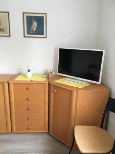 a television sitting on top of a wooden dresser at Haus Ursula 2 in Brake