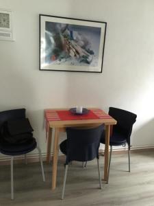 a table with chairs and a plate on top of it at Haus Ursula 2 in Brake