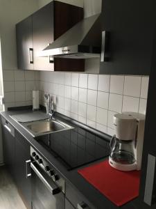 a kitchen with a coffee maker on a red rug at Haus Ursula 2 in Brake