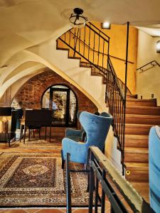 ein Wohnzimmer mit einer Treppe und einem blauen Stuhl in der Unterkunft Hotel Glaus in Banská Štiavnica