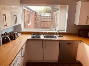 cocina con fregadero y ventana en Comfy House with Parking for Multiple Vehicles, en Cardiff