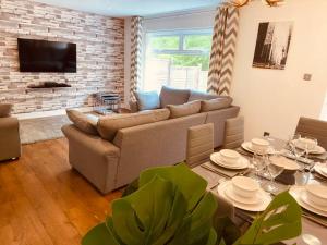 uma sala de estar com um sofá e uma mesa em Comfy House with Parking for Multiple Vehicles em Cardiff