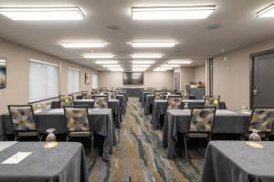 a conference room with tables and chairs and a screen at Oxford Suites Portland - Jantzen Beach in Portland +50 photos