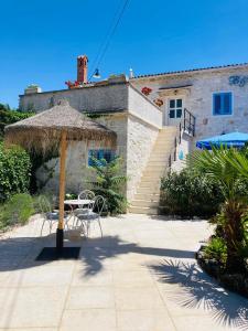 a patio with a table and an umbrella at B&B Nostromo in Funtana