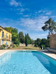 una gran piscina azul junto a una casa en Chenevières d'en Haut, en Grimault