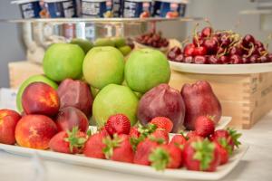 a display of apples and strawberries on plates on a counter at The Rif - Boutique Hotel in Pisa