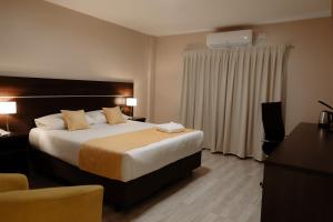 a hotel room with a bed and a desk at Hotel Batista in Posadas