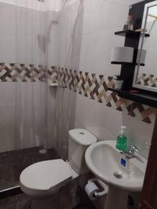 a bathroom with a white toilet and a sink at Kazasha-Bari in Barichara