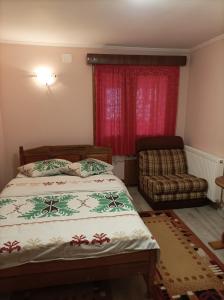 a bedroom with a bed and a chair and a window at Vila Alpina Olănești in Băile Olăneşti +20 photos