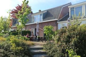 ein Haus mit Leuten, die an einem Tisch im Garten sitzen in der Unterkunft B&B - Pension Het Oude Dorp in Katwijk