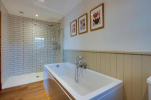 ein Badezimmer mit einer Badewanne und einem Waschbecken in der Unterkunft Home Farm B&B - Poppy Room in Forfar