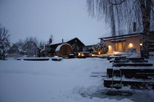 a house covered in snow at night with lights at Purde Puhkemaja - Hot Tub l Sauna l BBQ in Elva