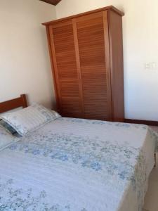 1 dormitorio con 1 cama y armario de madera en Apartamento Exclusivo Búzios Centro, en Búzios