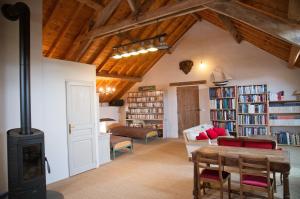 ein Wohnzimmer mit einem Holzofen und Bücherregalen in der Unterkunft Chambre d'Hôtes des Grands Moulins de Baugé in Baugé