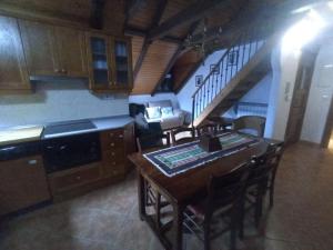 uma cozinha com uma mesa e cadeiras e uma escadaria em Apartamentos Sorripas 2 hab em Bielsa