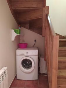 uma máquina de lavar roupa num pequeno quarto com uma escada em Apartament dúplex d'una habitació em Borredá