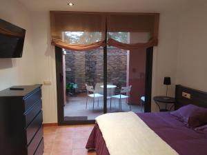 um quarto com uma cama e vista para um pátio em Apartament dúplex d'una habitació em Borredá