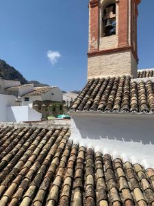 a building with a clock tower on top of a roof at Apartamento El Campanario in Zuheros +10 photos